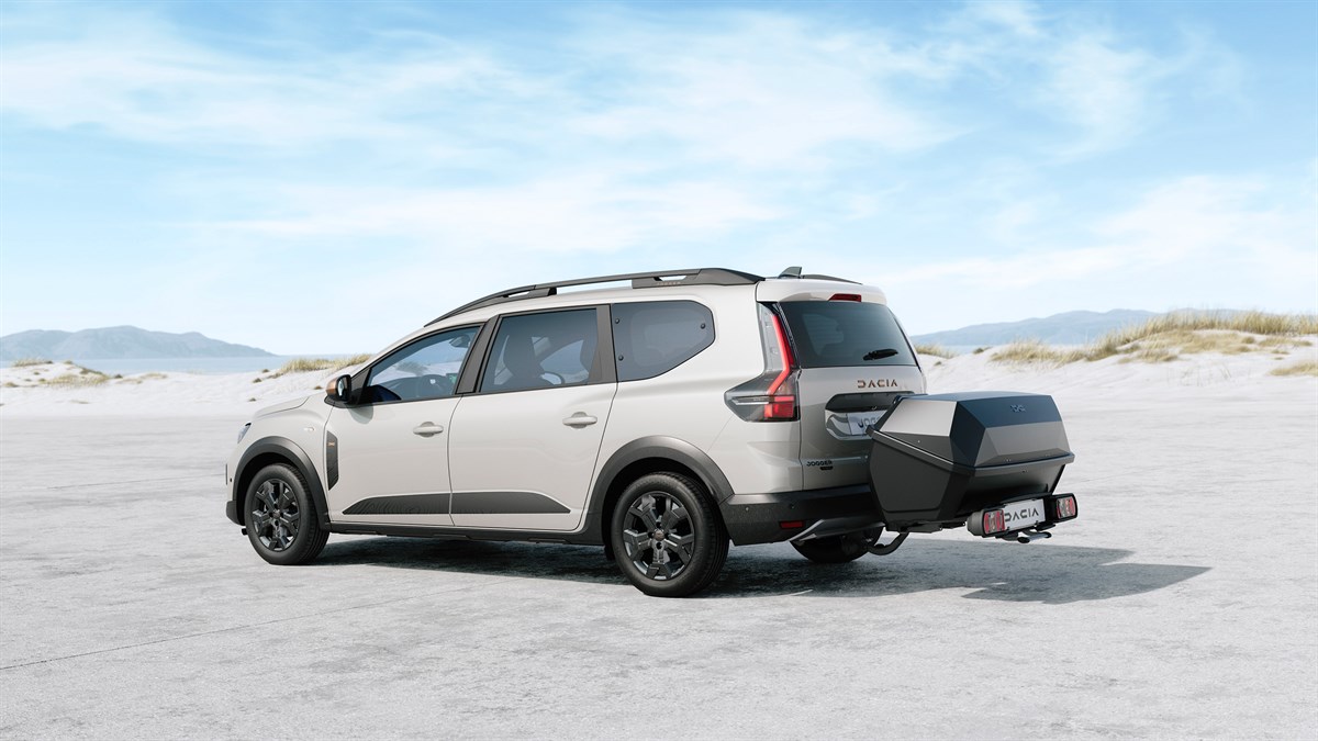 Возило Dacia Jogger во отворен простор со велосипед прикачен на држачите на кровот.