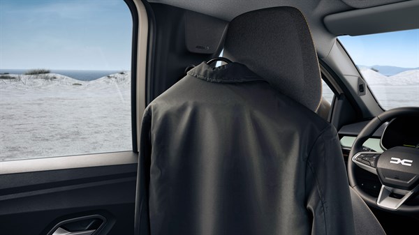 Палто закачено на закачалката YouClip монтирана на потпирачот за грб на Dacia Jogger.