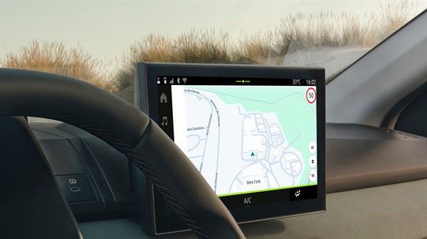 Централниот дисплеј на возилото ја прикажува мапата за навигација на системот Media Nav Live, со дел од управувачот  и инструмент таблата во рамката.