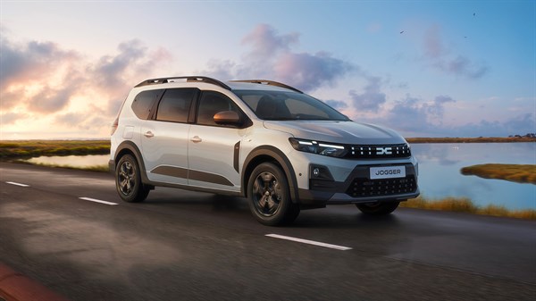Dacia Jogger фотографиран од напред, возејќи покрај езеро и поле со трска.