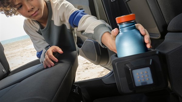 Дете поставува шише во држачот за шише YouClip прикачен на задниот дел од седиштето во Dacia Sandero Stepway.