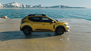 Жолто возило Dacia Sandero прикажано од задната страна покрај море.