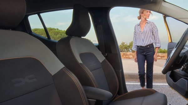 Внатрешноста на Dacia Sandero Stepway со perivim навлака Microcloud, насочен кон предните седишта и отворените врати.